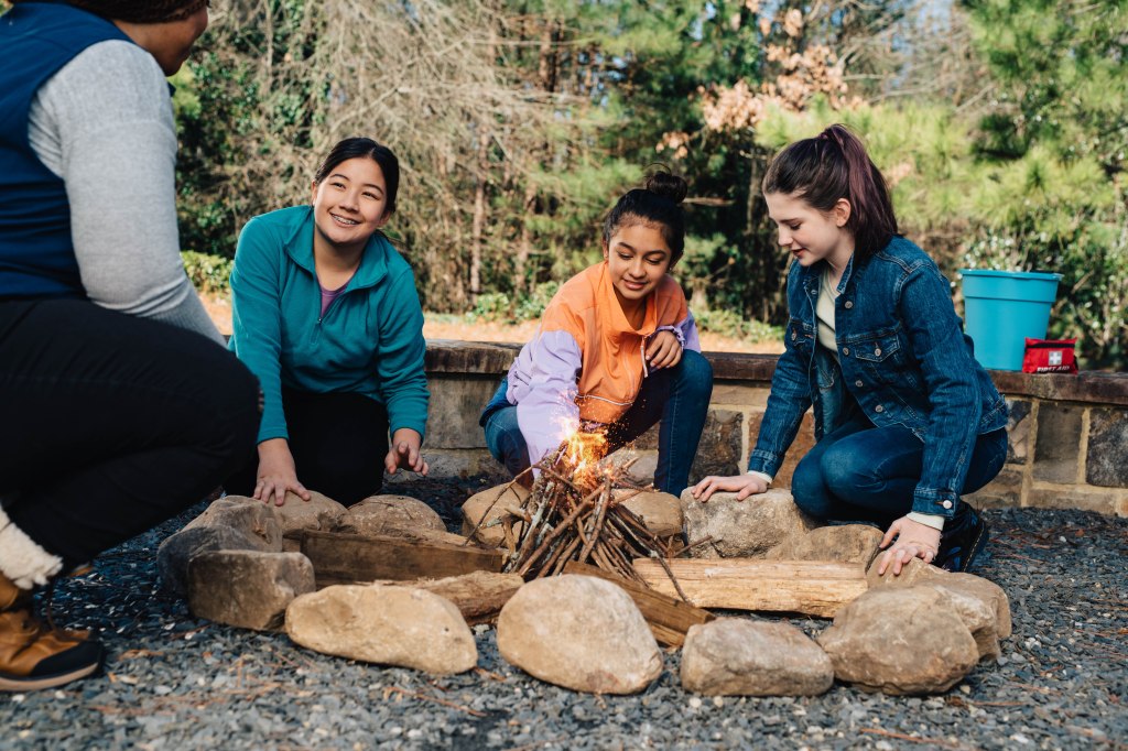Photo of Girl Scouts creating a camp fire.